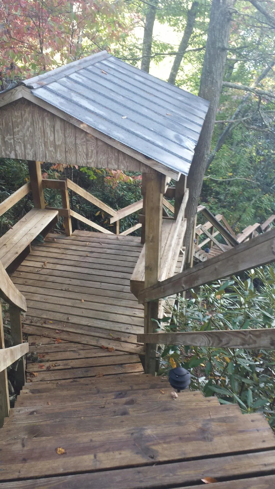 Metal roofed shelter over wooden steps on a wooded walkway — Skylight Repair & Installation work by our crew in Vernon