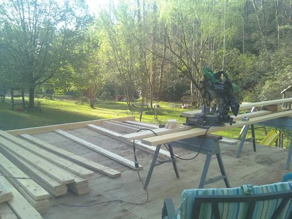 Miter saw and framing lumber on a deck under construction in Vernon